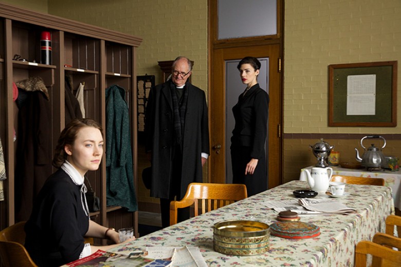 Saoirse Ronan as “Eilis,” Jim Broadbent as “Father Flood” and Jessica Paré as “Miss Fortini” in BROOKLYN. Photo by Kerry Brown. © 2015 Twentieth Century Fox Film Corporation All Rights Reserved
