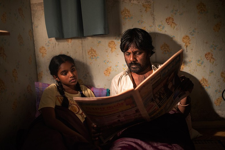 Dheepan Jesuthasan Antonythasan (Dheepan) Claudine Vinasithamby (Illayaal) reading the newspaper in Jacques Audiard’s DHEEPAN. Courtesy of Paul Arnaud. A Sundance Selects release.