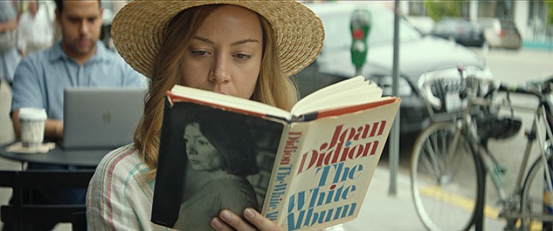 Ingrid (Aubrey Plaza) reads in a public place in INGRID GOES WEST, courtesy of NEON