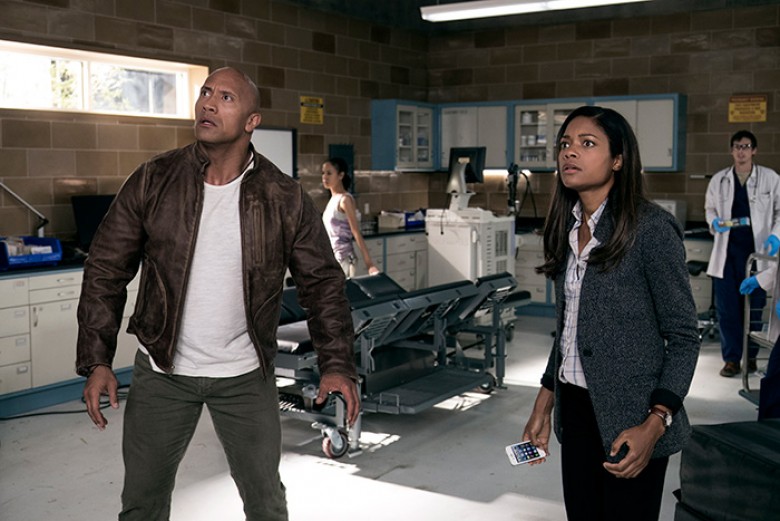 © 2018 WARNER BROS. ENTERTAINMENT INC. Photo Credit: Frank Masi Caption: (L-R) DWAYNE JOHNSON as Davis Okoye and NAOMIE HARRIS as Dr. Kate Caldwell in New Line Cinema’s and ASAP Entertainment’s action adventure “RAMPAGE,” a Warner Bros. Pictures release.