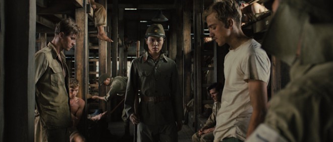 (L to R, foreground) The Bird (MIYAVI) terrifies POWs in “Unbroken.” Photo Credit: Universal Pictures Copyright: © 2014 Universal Studios. ALL RIGHTS RESERVED.