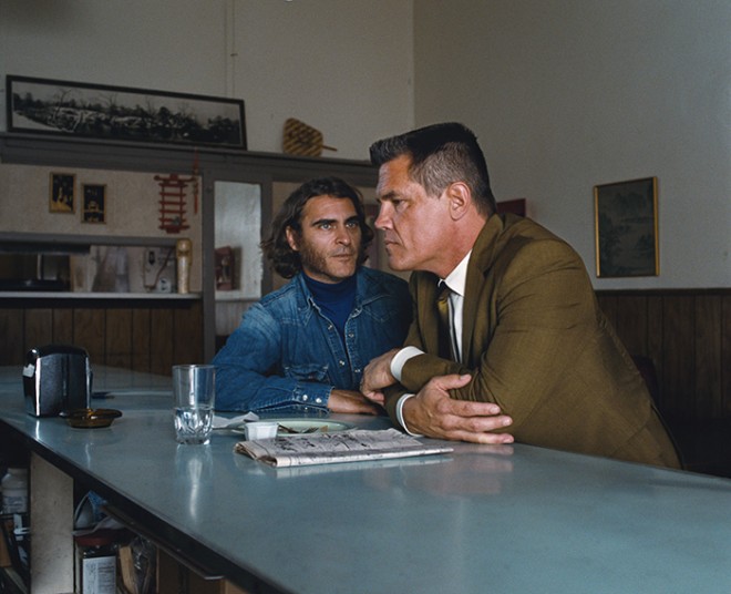 Copyright: © 2014 WARNER BROS. ENTERTAINMENT INC. AND RATPAC-DUNE ENTERTAINMENT LLC ALL RIGHTS RESERVED Photo Credit: Courtesy of Warner Bros. Pictures Caption: (L-r) JOAQUIN PHOENIX as Larry “Doc” Sportello and JOSH BROLIN as Lt. Det. Christian F. “Bigfo