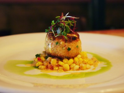 Pan fried Caribbean Laughing Bird shrimp cake, fresh corn salad, Cajun remoulade, basil oil.